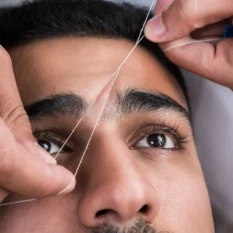 man having eyebrow threading